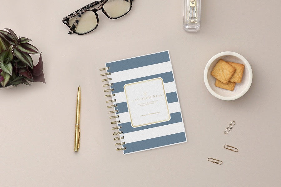 2026 daily monthly from day designer for blue sky featuring a hardcover, navy blue and white stripe design, gold twin wire-o binding in a compact 5x8 planner size.