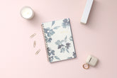 academic weekly monthly planner featuring a white background and blue paint brush florals, twin wire-o binding in a 5x8 planner size for the school year july 2024- june 2025
