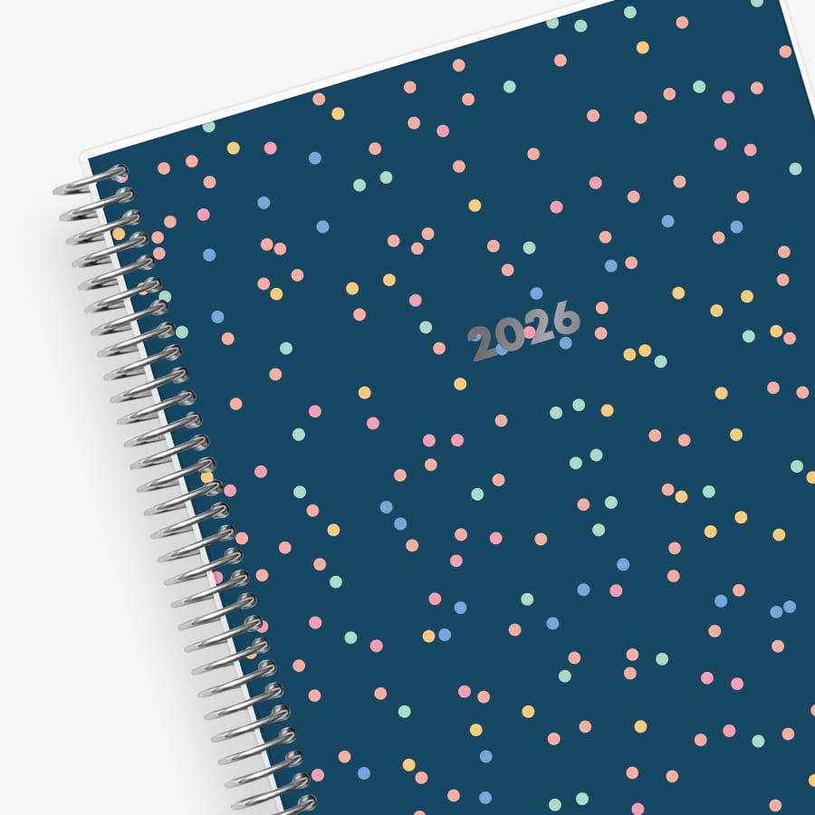 Spiral-bound planner with a blue cover featuring colorful polka dots and &