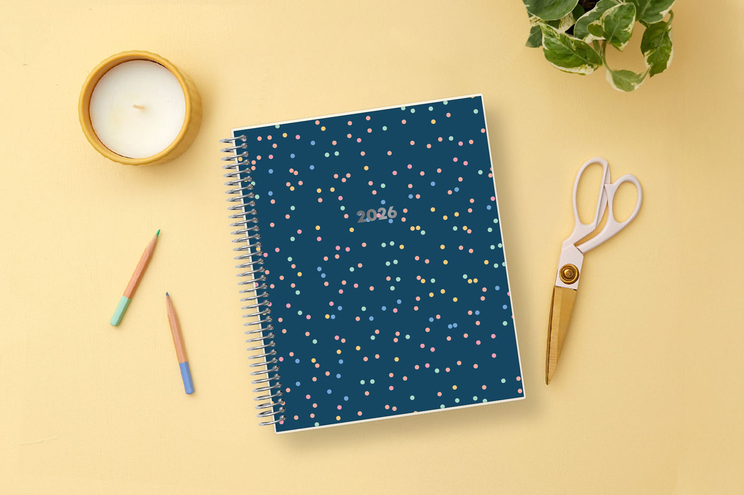 Spiral-bound planner with a blue cover featuring colorful polka dots and &