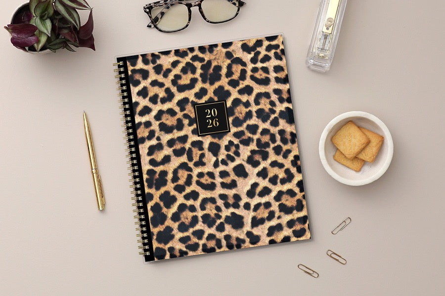 Leopard print planner with a gold spiral binding and &