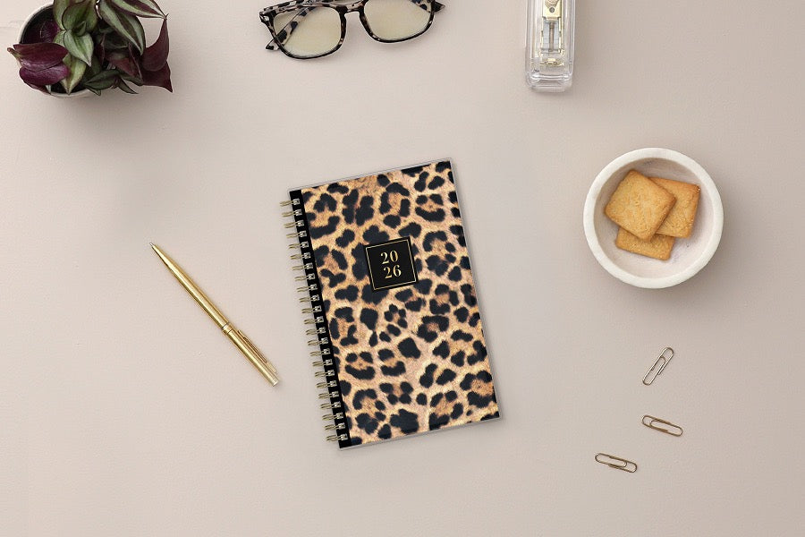 Leopard print planner with a gold spiral binding and &