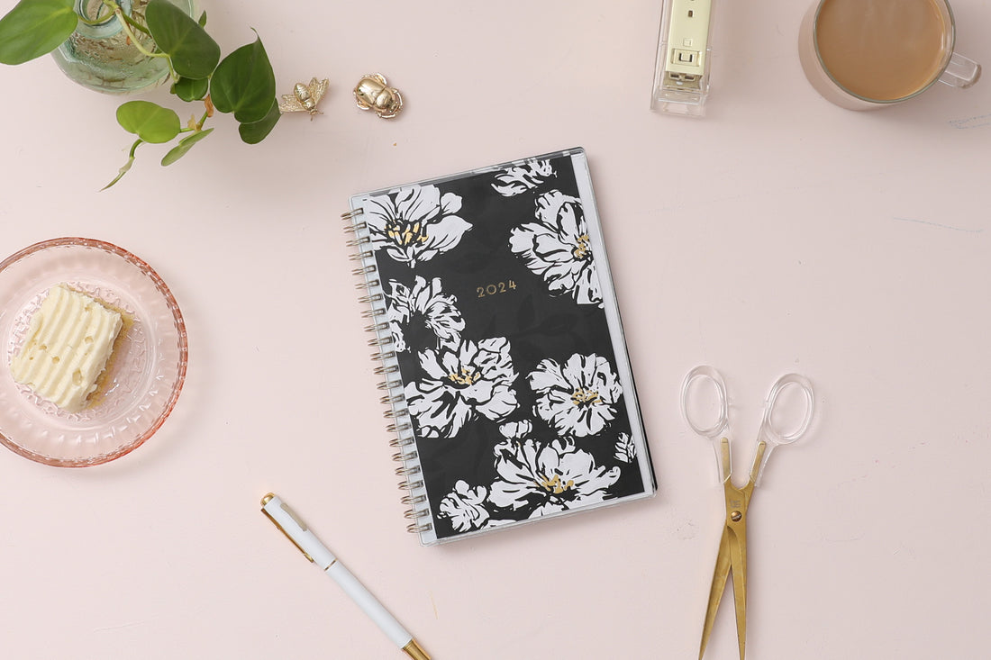 5x8 weekly monthly planner for January 2024 - December 2024 new year featuring silver twin wire-o binding, black/gray background, white florals and gold accents
