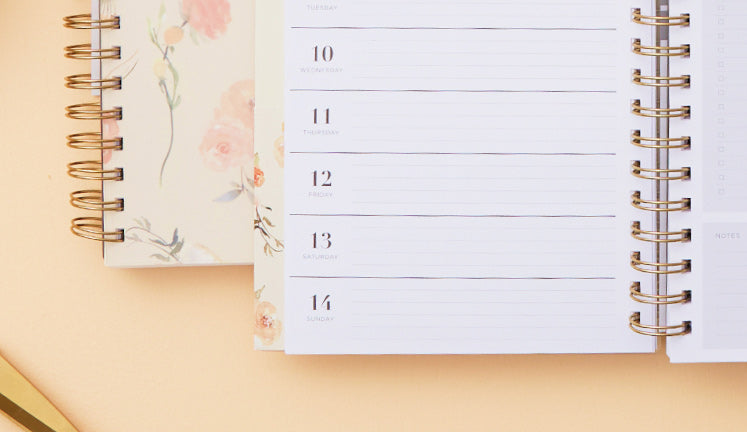 An open planner on a peachy-beige backdrop.