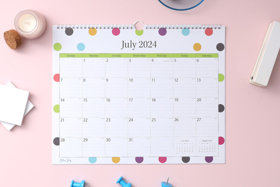 teacher dots calendar in 15x12 planner size with lined writing space and reference calendars July 2024- june 2025 lifestyle photo with push pins, stapler, candle, and post-its notes on the side.