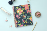 weekly monthly academic planner from Day Designer for Blue Sky featuring a navy background and floral front cover 8.5x11, lifestyle photo on a mint background with pen, macoroon, stapler, and paperclip on the side. 2024-2025 academic year