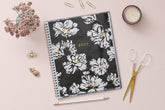 Plan way with this January 2025 - December 2025 monthly planner featuring a floral pattern front cover and gold silver wire-o binding