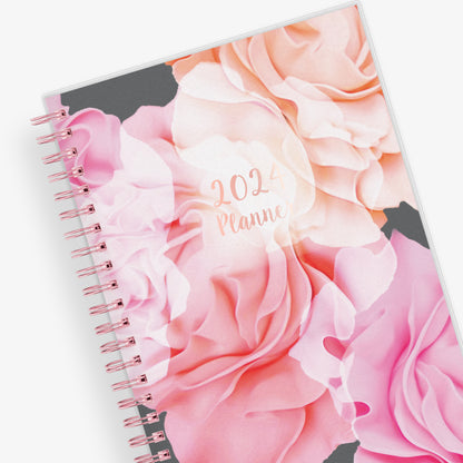 Take planning to the next level with this 2024 weekly monthly planner from Blue Sky featuring a cover with beautiful roses in shades of pink, rose gold twin wire-o binding in 5x8 planner size, and flexible front cover.