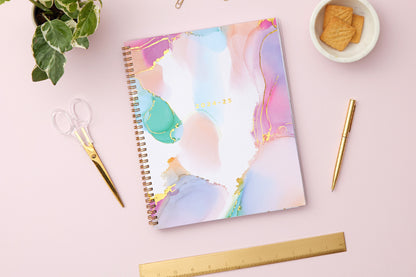 weekly monthly planner by Ashley g for blue sky featuring a marble like pattern front cover and gold twin wire-o binding in 8.5x11 size 2024-25 year
