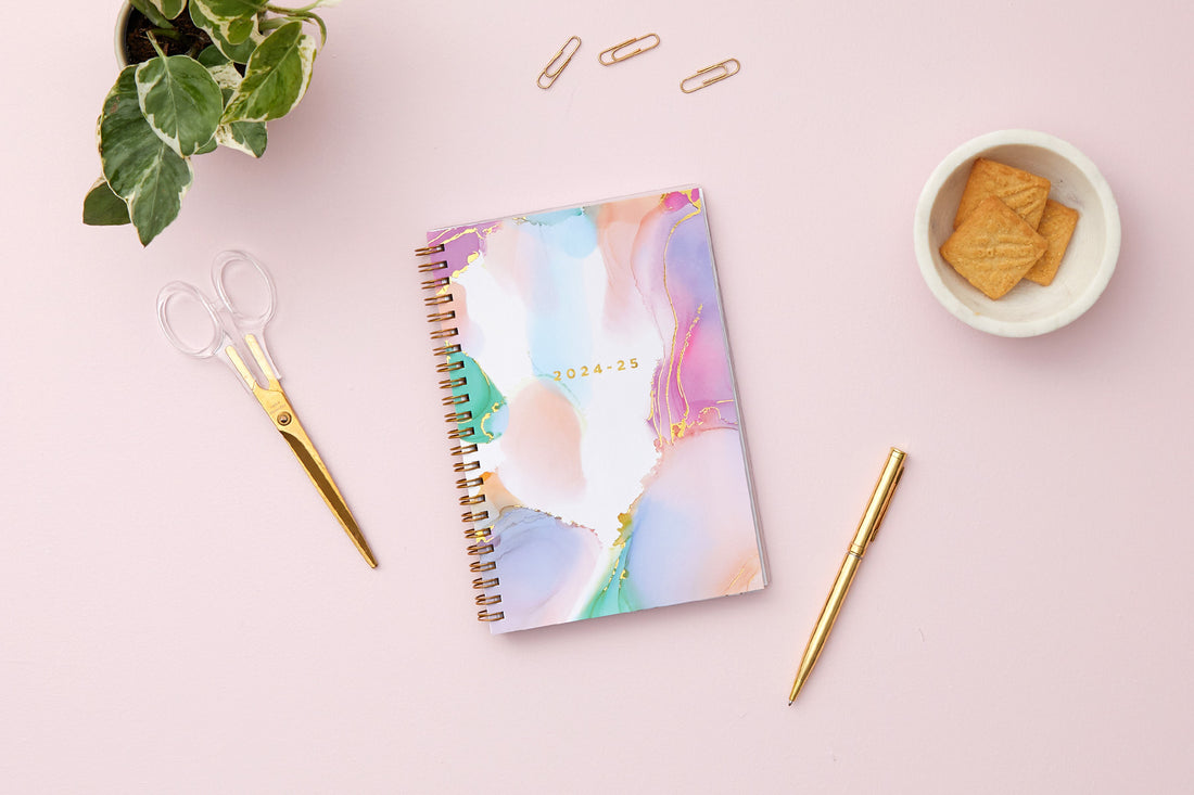 weekly monthly planner by Ashley g for blue sky featuring a marble like pattern front cover and gold twin wire-o binding in 5x8 size 2024-2025 year