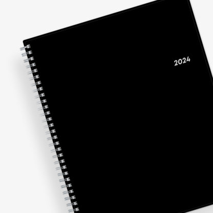 Bilingual January 2024 - December 2024 weekly monthly planner featuring a charcoal front cover design and silver twin wire-o binding 8.5x11 size Calendario De Planificacion.