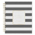 A spiral-bound planner with horizontal gray and white stripes, featuring a central gold foil label that reads &