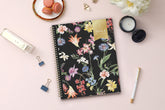 January 2024 - December 2024 featuring floral pattern on a black backcover and gold twin wire-o binding in 8.5x11 planner size