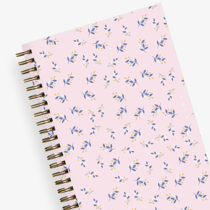 this one tree planted partnership planner for 2024 featuring a floral front cover with pink background and gold twin wire o binding in 5x8 planner size.