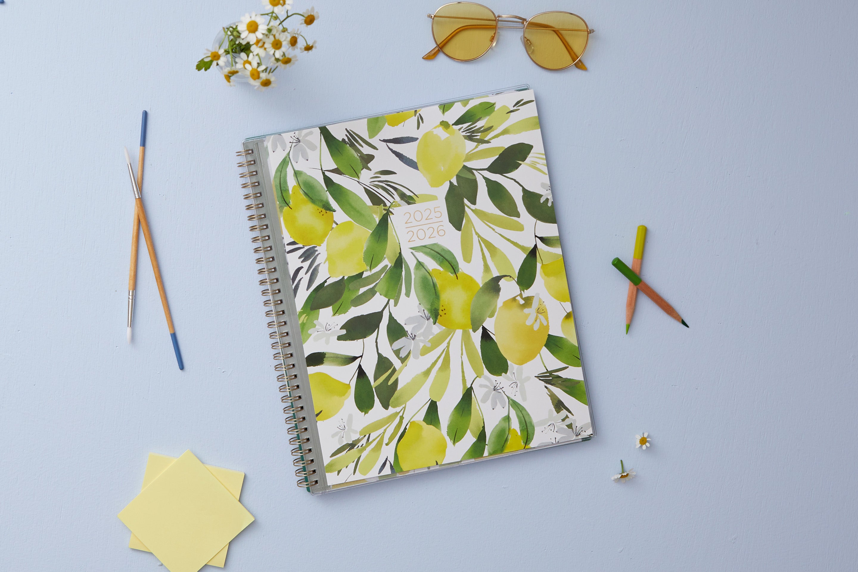 The kelly ventura 2025-2026 weekly monthly planner for blue sky features beautiful lemons cover with gold twin wire-o binding in a 8.5x11 planner size.