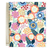 Floral patterned weekly premium planner with a gold spiral binding on a white background