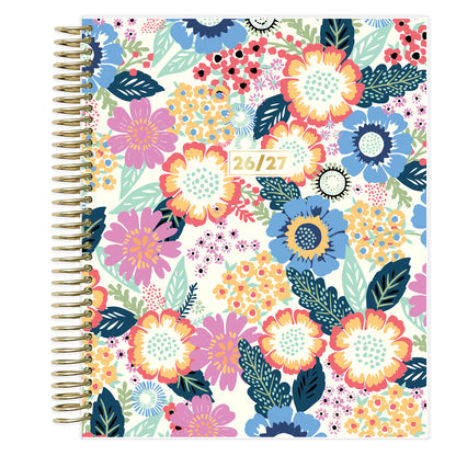 Floral patterned weekly premium planner with a gold spiral binding on a white background