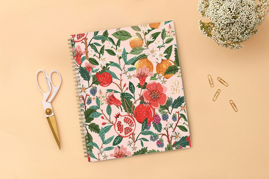 Spiral-bound 2026 planner with floral and fruit design on a pink background