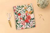Spiral-bound 2026 planner with floral and fruit design on a pink background