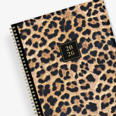 Leopard print planner with a gold spiral binding and &