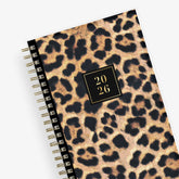 Leopard print planner with a gold spiral binding and &