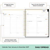 An open spiral-bound daily planner spread showing a January 2027 daily layout with labeled callouts about weekly planning, to-do checklists, and vertical time slots from 6am to 8pm.