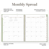 An open spiral-bound monthly planner spread shown on a white background with callout labels describing features such as a dedicated top three and to-do task list, reference calendars, spacious month-at-a-glance layout, monthly actions task list, and daily lined blocks.