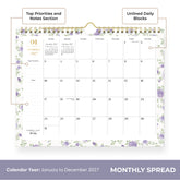 A spiral-bound monthly calendar page for January 2027, featuring a white background with light purple floral borders and gold accents, including a gold spiral binding and a gold clip at the top.