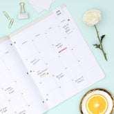 this july 2026 - june 2027 planner features a monthly spread with ample writing space for each day, monthly reference calendar, sections for note taking, bullet points, and check lists.
