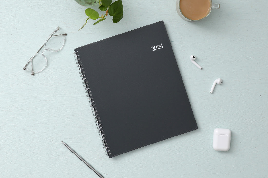 The January 2024 - December 2024 weekly appointment book from Blue Sky features a flexible charcoal front cover and twin silver wire-o binding