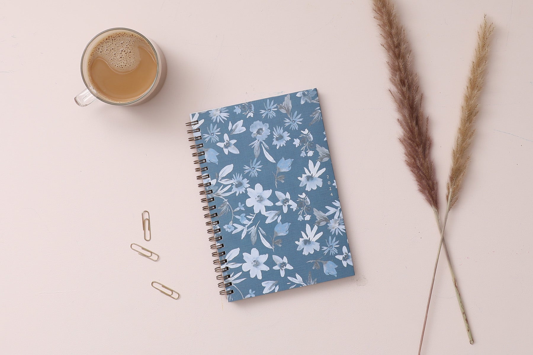 2024 blue sky sustainability weekly monthly planner featuring white and blue floral patterns on a dark blue background 5x8 gold wire-o