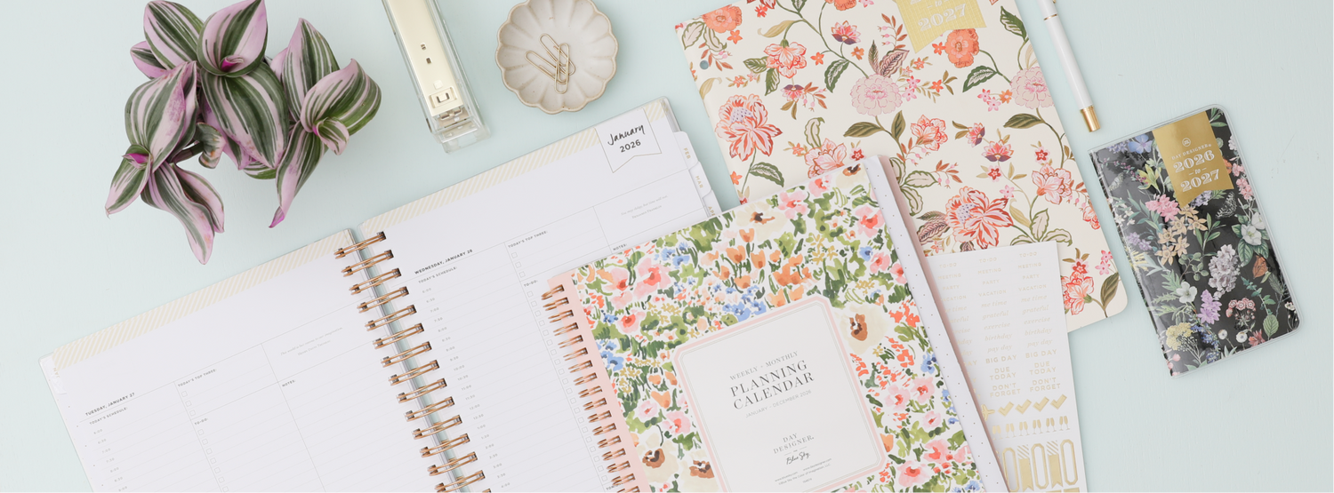 Day Designer floral planner and accessories on a light blue surface