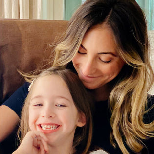 Emily Schuman from Cupcakes and Cashmere sitting with her daughter