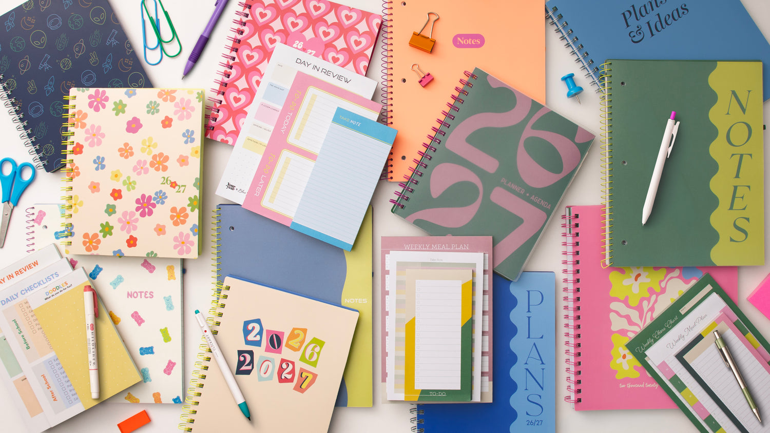assorted collection of notebooks, planners, pens, and notepads