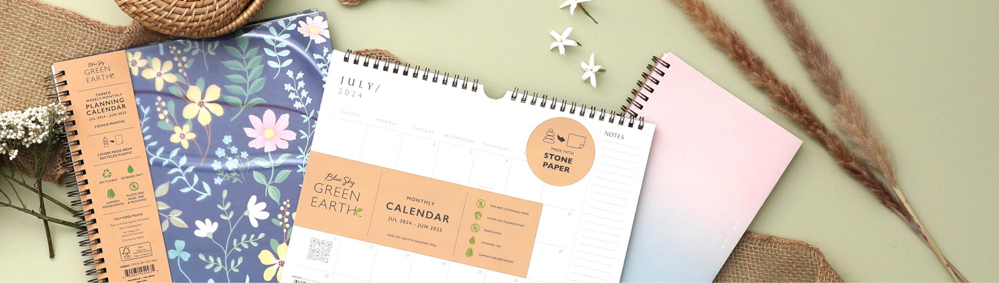 Blue Sky Green Earth planners and calendar on top of a flat-lay scene with floral