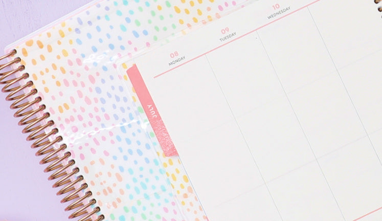 Spiral-bound LiveWell planners against a lavender backdrop