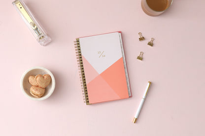 July 2023-2024 weekly and monthly planner for academic year featuring a geometric design in palette of pinks and white in 5x8 planner size