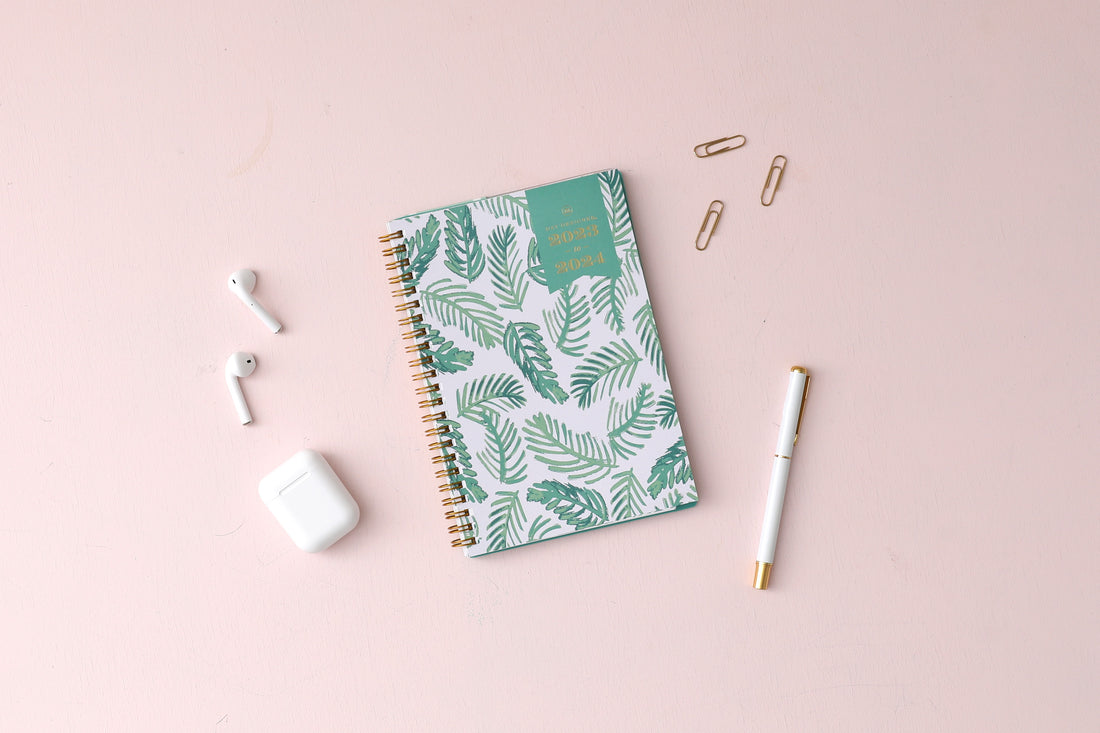 2023-2024 weekly and monthly day designer planner for blue sky featuring palms front cover silver wire-o binding in a 5x8 planner size