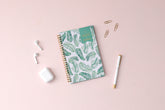 2023-2024 weekly and monthly day designer planner for blue sky featuring palms front cover silver wire-o binding in a 5x8 planner size